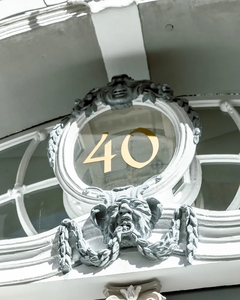 Goldene Hausnummer 40 an der weißen Fassade des Studios in der Mengstraße